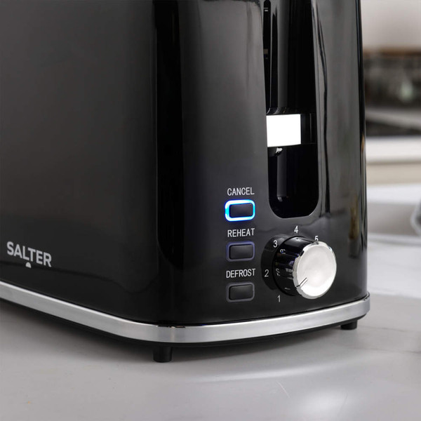 Black Salter toaster close-up showing cancel, reheat, and defrost buttons with dial.