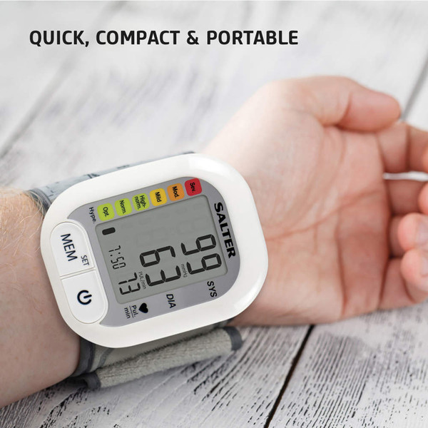 Wrist blood pressure monitor on arm showing display, compact portable design