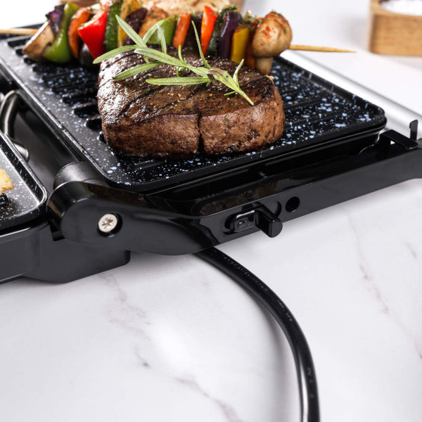 Close-up of black speckled electric grill plate with ridged surface