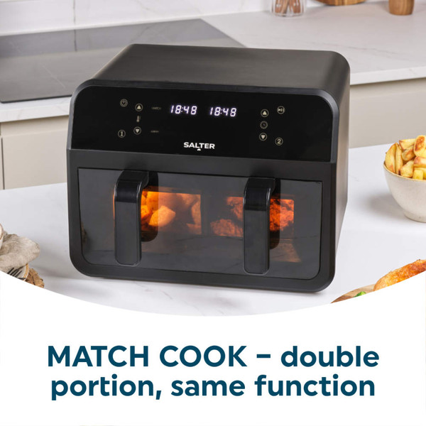 Black digital air fryer with sweet potato fries in one drawer, hand removing divider