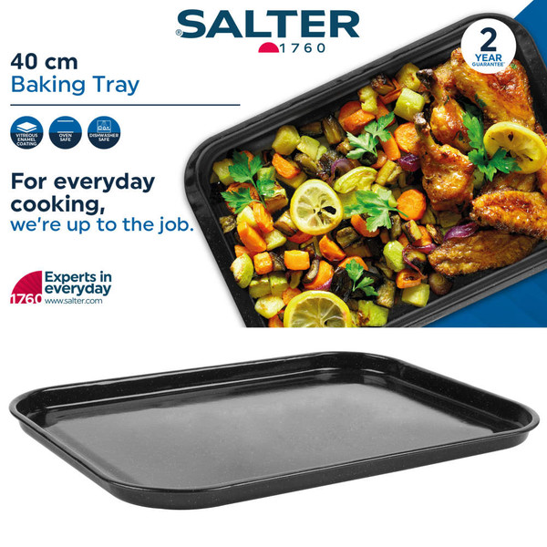 Black enamel roasting tray with assorted roasted vegetables on kitchen worktop