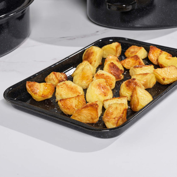Roast potatoes on a black enamel oven tray