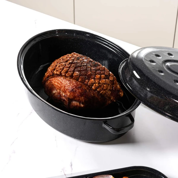 Roast joint in a black speckled enamel roasting pan with lid, shown on a kitchen counter.