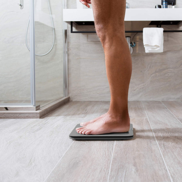 Person standing on digital bathroom scales in modern bathroom