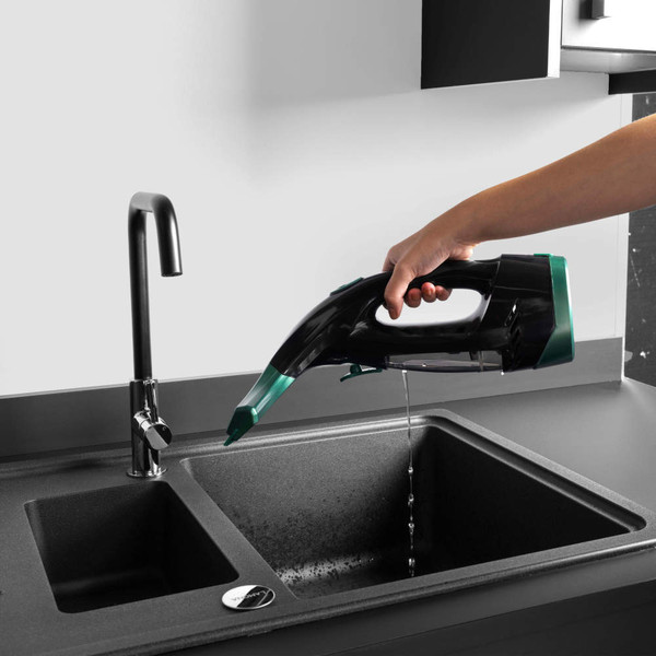 Hand holding handheld vacuum cleaner over sink, emptying water from dust bin.
