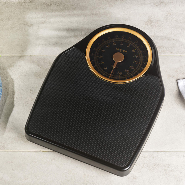 Black mechanical bathroom scales with gold dial, Salter brand, 'No battery required' text.