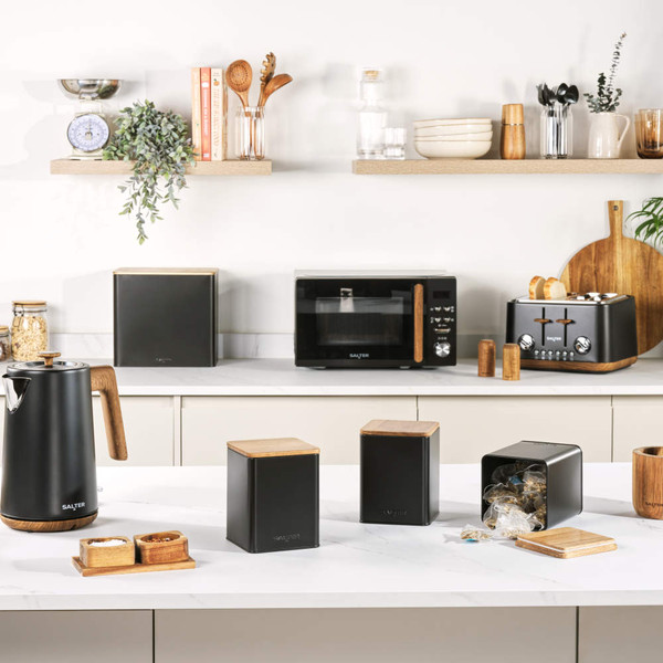Black Salter microwave with wood-effect handle, hand opening door on a kitchen counter