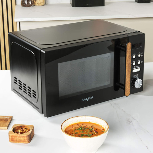 Black Salter microwave with wood-effect handle on kitchen counter, soup in foreground