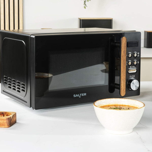 Black Salter microwave with wood-effect handle, shown on kitchen counter with hand opening door