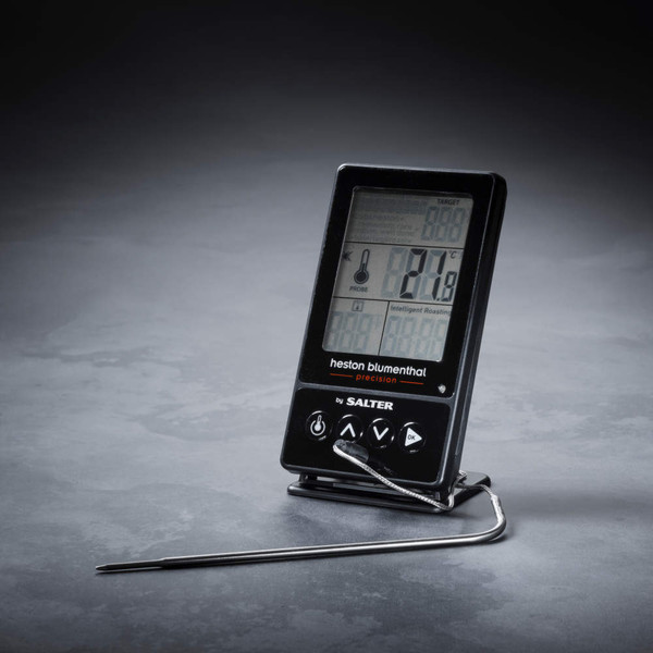 Digital cooking thermometer with probe, upright on grey surface