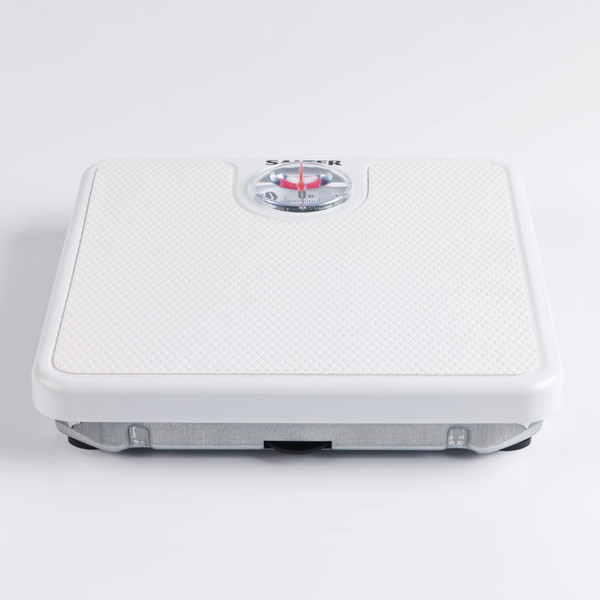 White mechanical bathroom scale with textured platform, viewed from above.