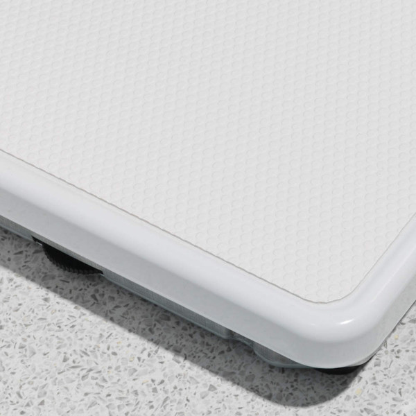 Close-up of white bathroom scale corner showing textured surface