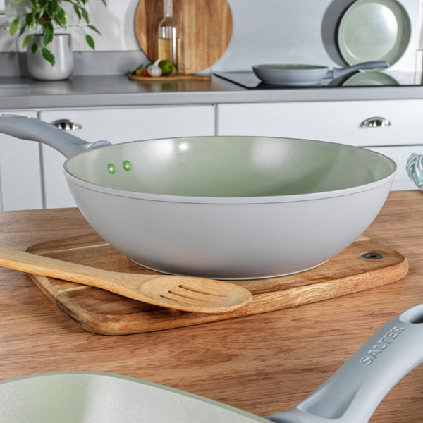 Salter light grey wok with green non-stick interior, shown on wooden board in modern kitchen