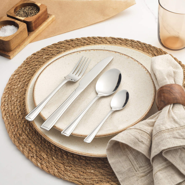 Four-piece stainless steel cutlery set with knife, fork, dessert spoon and teaspoon on table