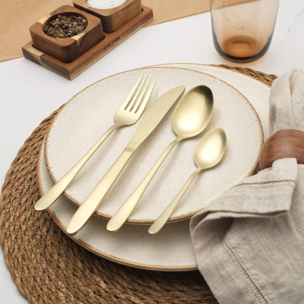 Set of four gold stainless steel cutlery pieces: knife, fork, tablespoon and teaspoon.