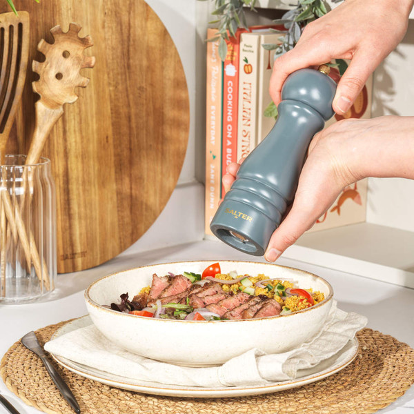 Grey Salter pepper mill in use seasoning steak salad in bowl