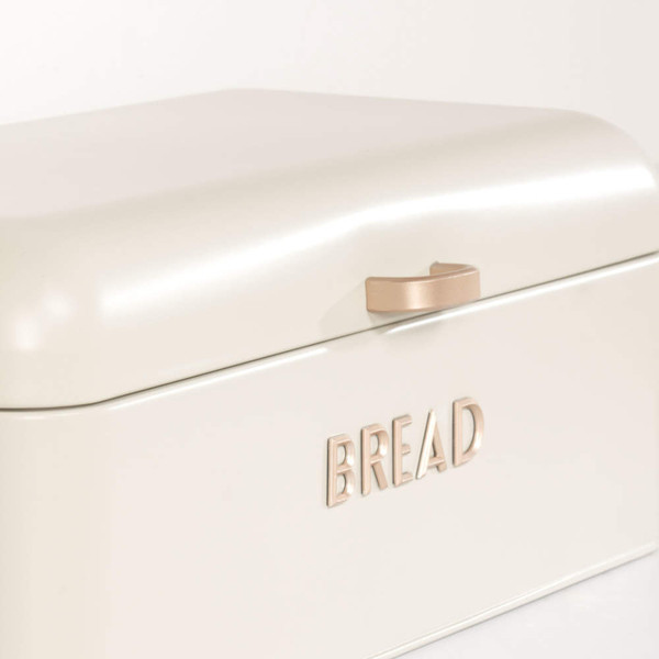 Cream metal bread bin with gold handle and raised BREAD lettering, shown from front angle