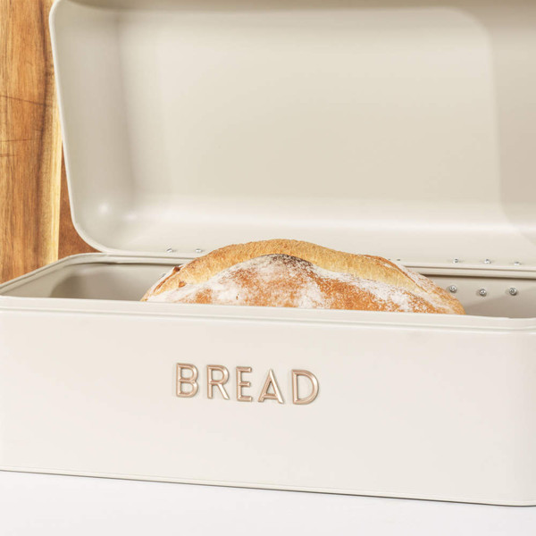 Cream metal bread bin with gold handle and raised BREAD lettering, shown from front angle