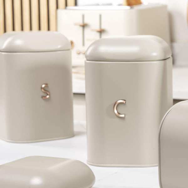 Cream metal storage tin with rose gold handle, containing tea bags
