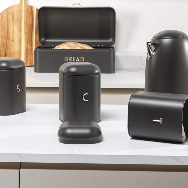 Black kitchen storage tins for salt, coffee, and bread, with metallic lettering.