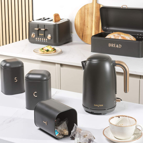 Black kitchen storage set with labelled canisters, bread bin and kettle on countertop