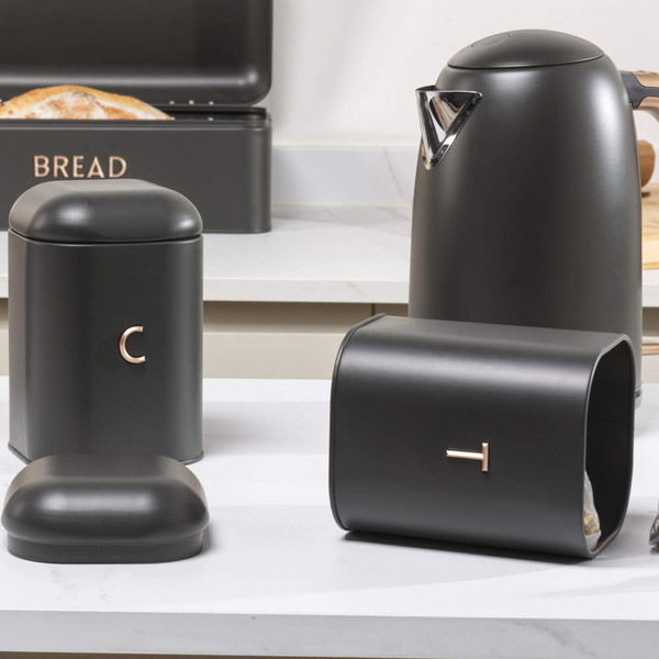 Black kitchen canisters set with kettle, bread bin and tea caddy on worktop