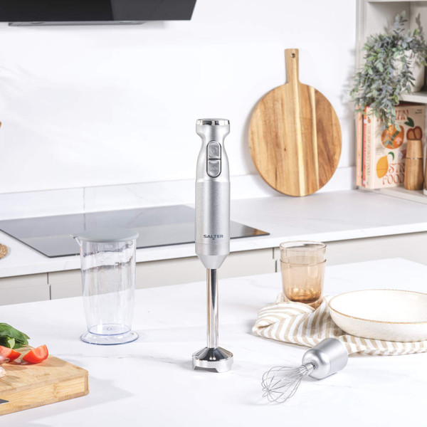 Silver hand blender set on kitchen counter with whisk and jug attachments displayed