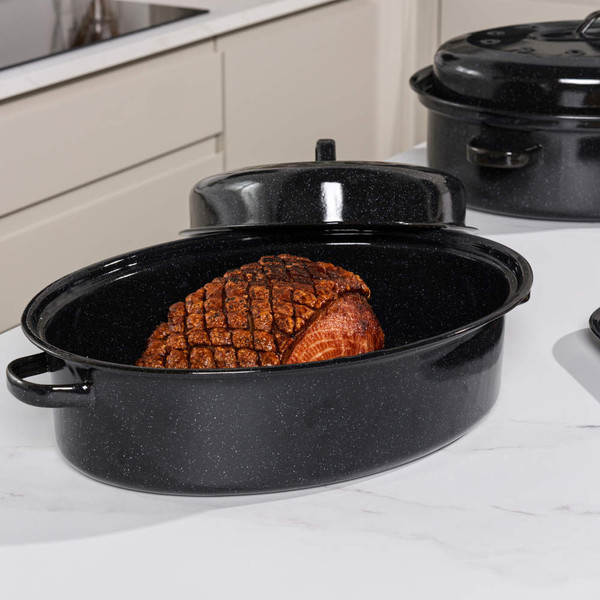 Roast joint in black enamel roasting pan with lid, shown on kitchen worktop