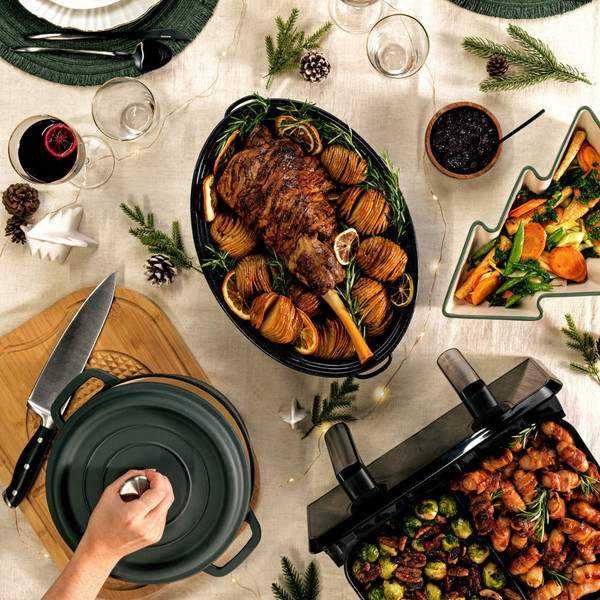 Festive roast lamb with hasselback potatoes and vegetables served on a holiday table