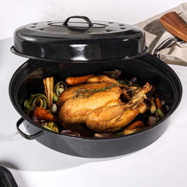Black enamel roasting set with lids, shown with roast and roasted vegetables on kitchen counter