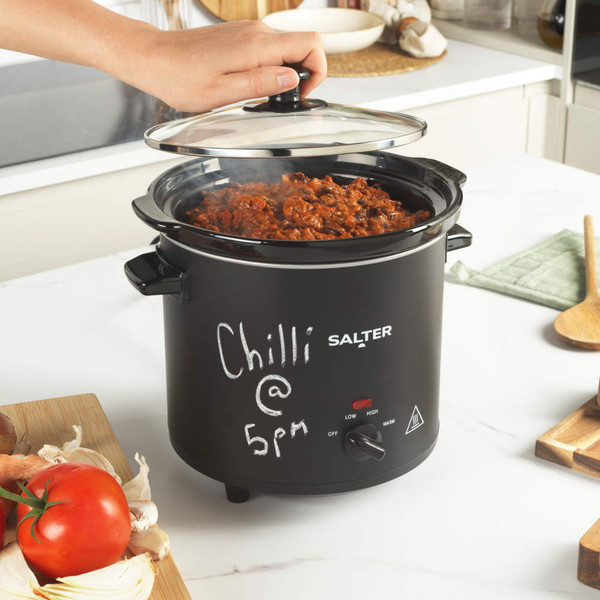 Black Salter slow cooker with glass lid, front controls and side handles on white background