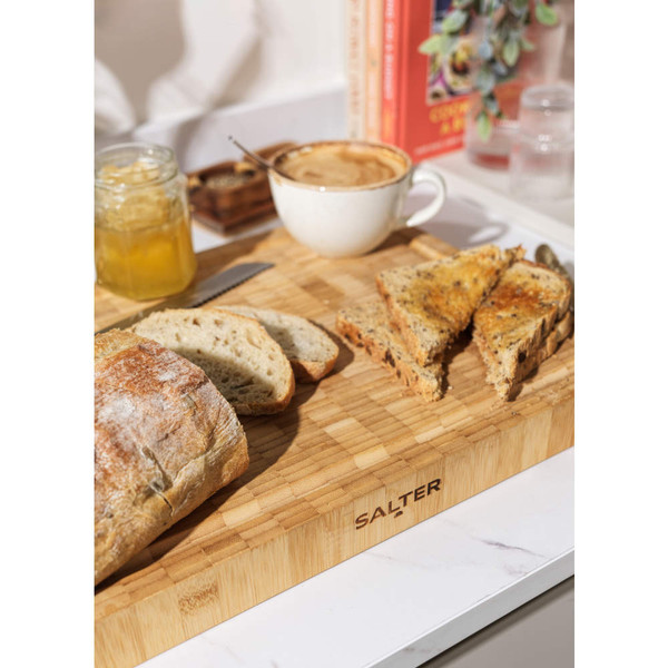 Sliced roast beef with garlic and herbs on wooden chopping board
