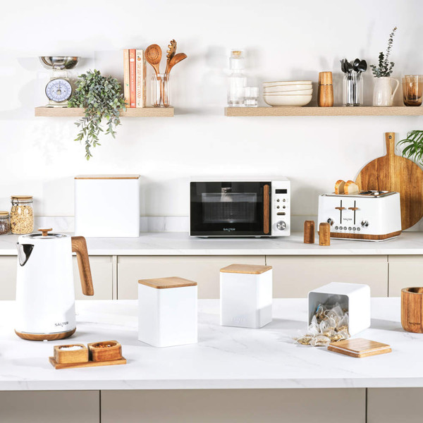 Modern white kitchen appliances and storage jars with wood accents on worktop