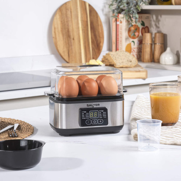 Egg boiler with six brown eggs and digital timer on kitchen counter