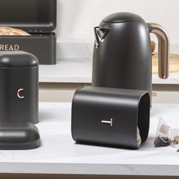 Matte black kitchen set with metal kettle, bread bin, tea and coffee canisters