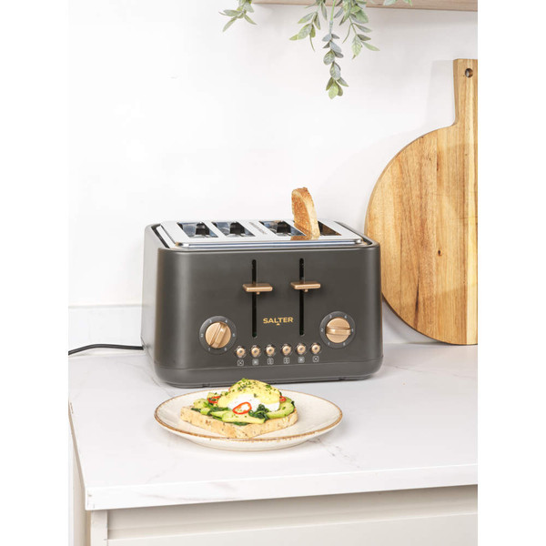 Four slice dark grey toaster with copper dials on kitchen counter