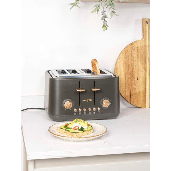 Four slice dark grey toaster with copper dials on kitchen counter