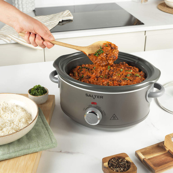 Salter grey slow cooker with chilli con carne being stirred, served with white rice.