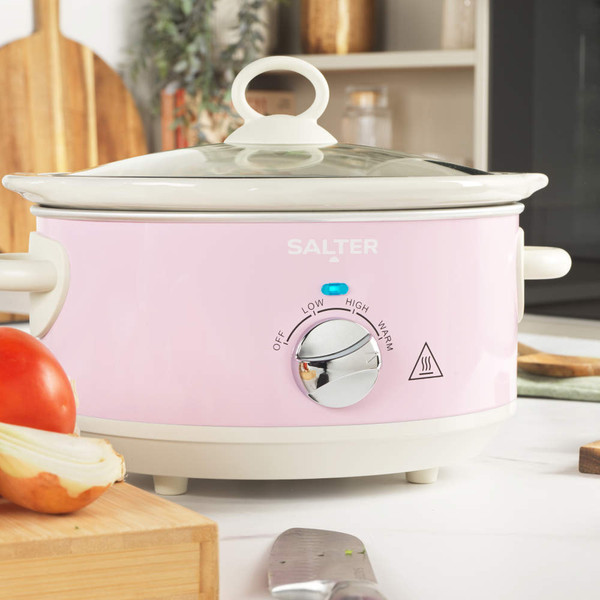 Pink Salter slow cooker with tomato stew, lid being lifted, kitchen counter setting