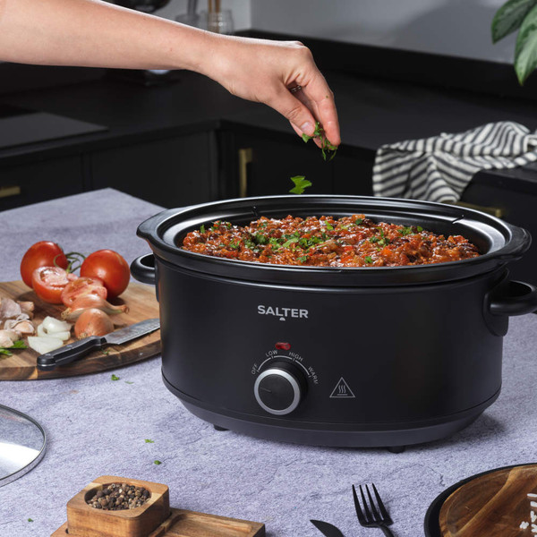 Black Salter slow cooker with glass lid shown on kitchen worktop