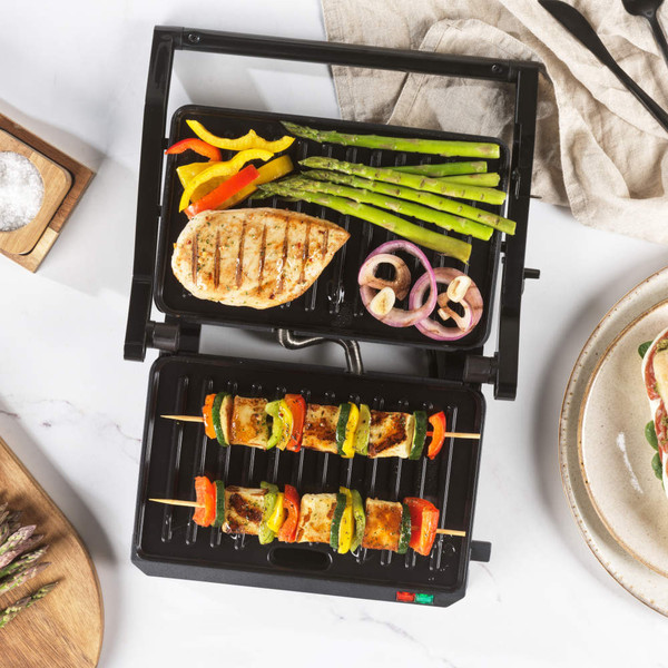 Black electric contact grill open, showing ridged plates, for sandwiches or paninis
