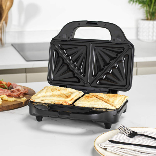 Black sandwich toaster with two toasted sandwiches in a modern kitchen