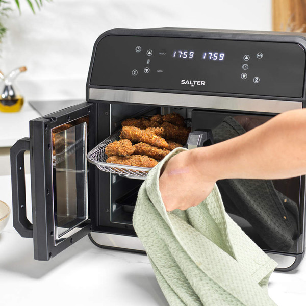 Salter digital air fryer oven with open door, showing tray of cooked chicken wings