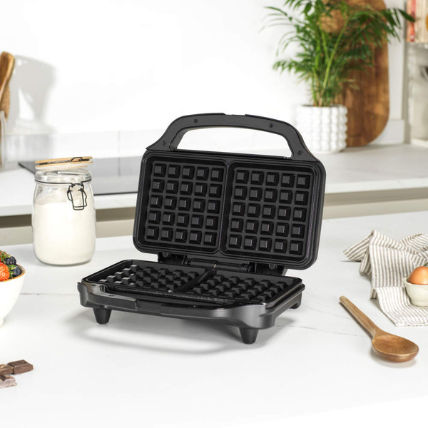Black waffle maker open on kitchen counter, ready for use