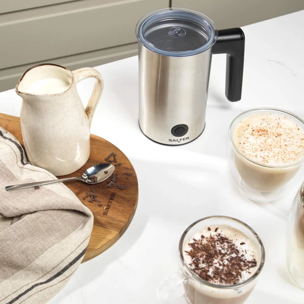 Stainless steel electric milk frother with black handle, shown upright