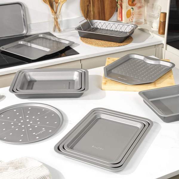 Set of non-stick grey baking trays and racks displayed on kitchen worktop