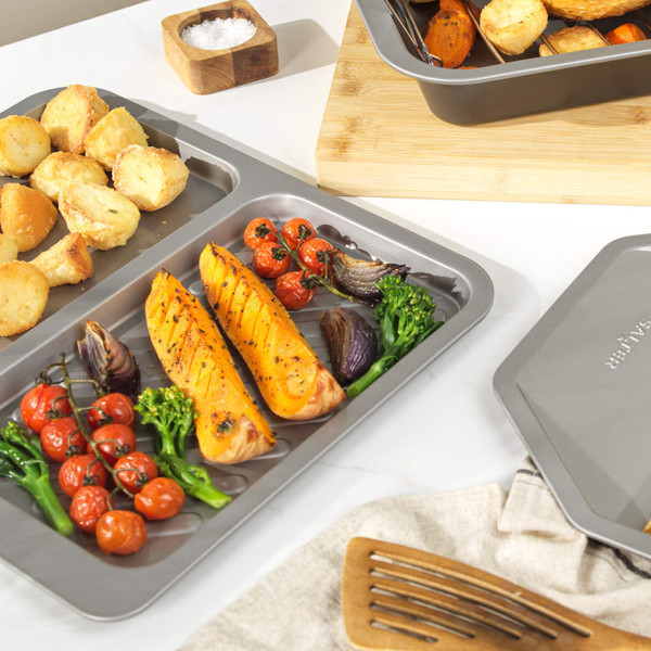 Grey non-stick oven tray with split grill and flat sections, top view