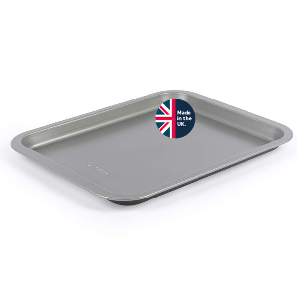 Non-stick grey baking tray with label showing 'Made in the UK', angled view.