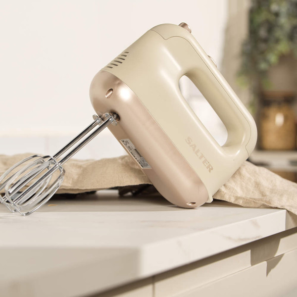 Cream hand mixer on kitchen counter, angled to show chrome whisks and Salter branding