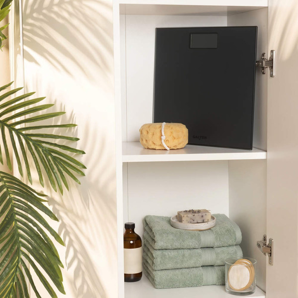Black bathroom scale with sponge on shelf
